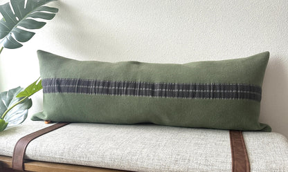 Green pillow with a long gray stripe on a bench