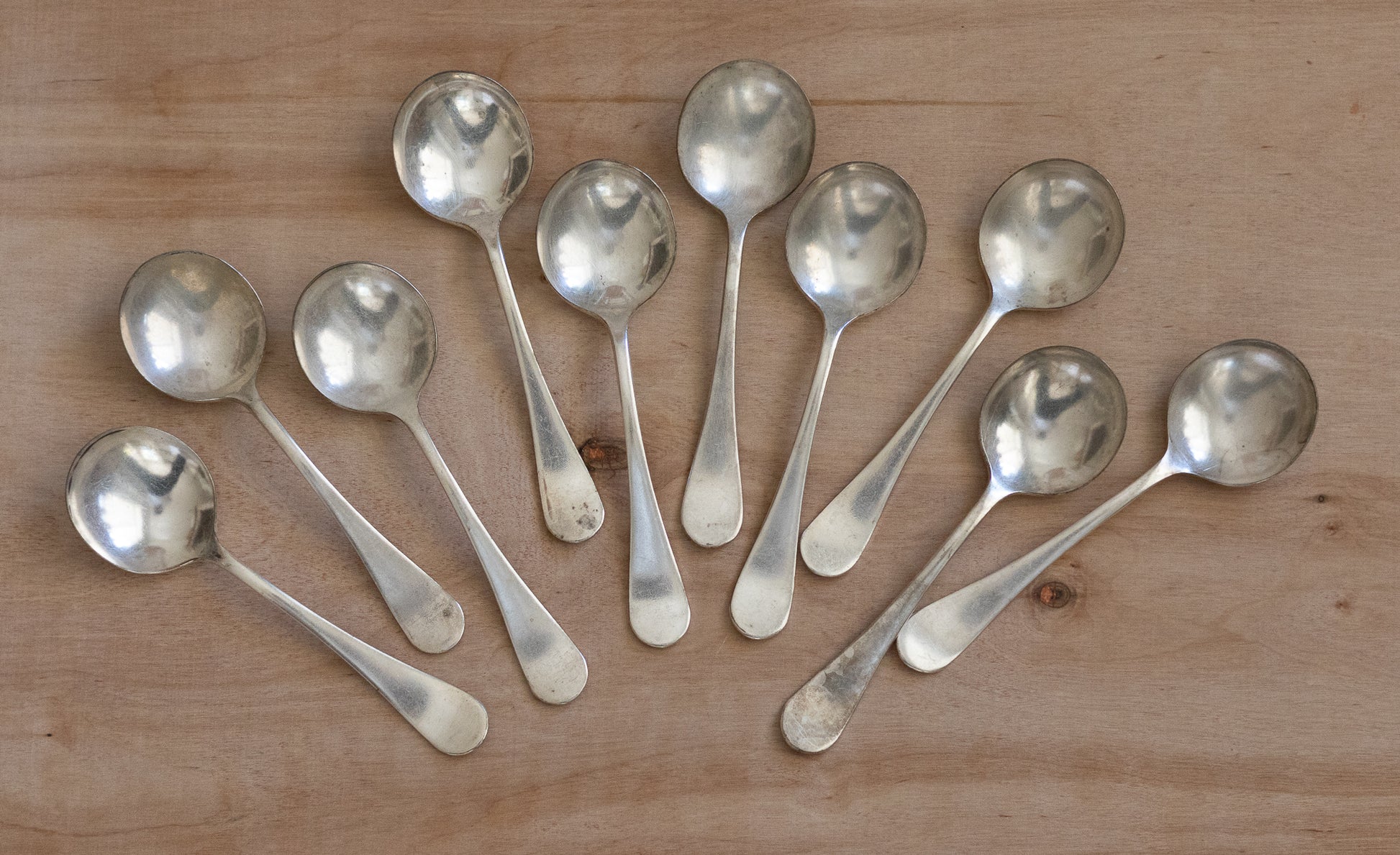 Set of silver spoons on a wooden surface