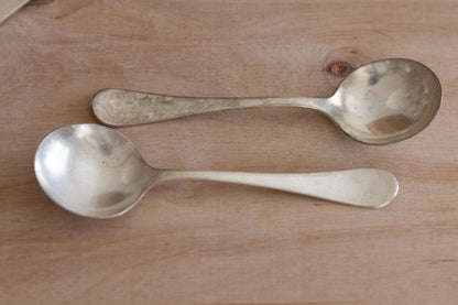 Two silver spoons on a wooden surface
