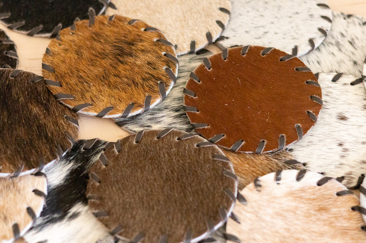 Close-up of leather coasters with different textures and colors.