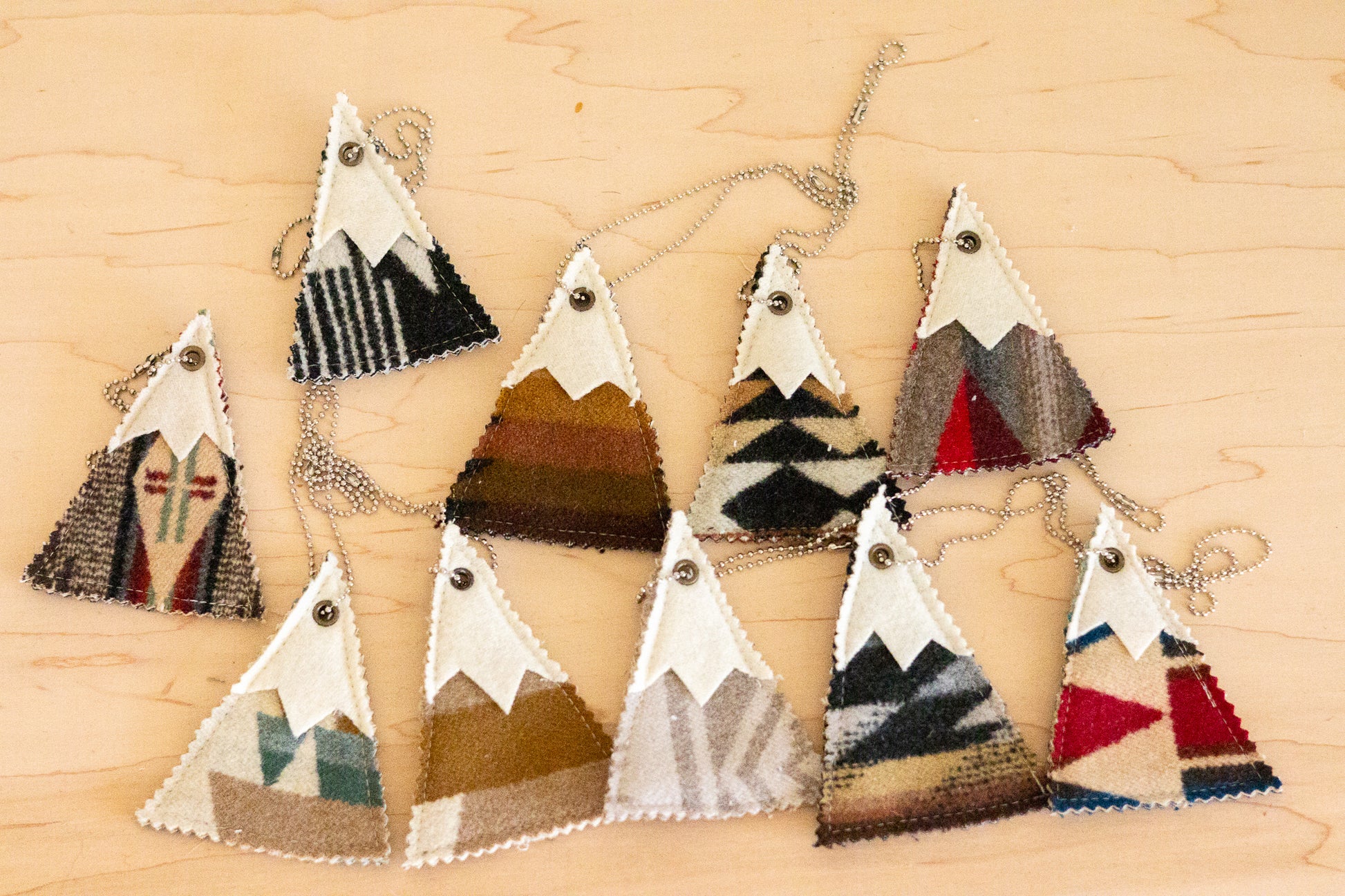 Set of geometrically patterned triangle-shaped ornaments on a wooden surface