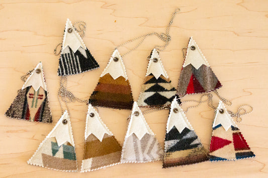 Set of geometrically patterned triangle-shaped ornaments on a wooden surface