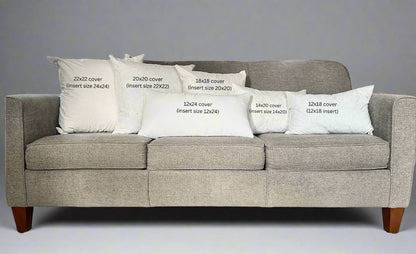 Gray sofa with white pillows displaying text about cover sizes.