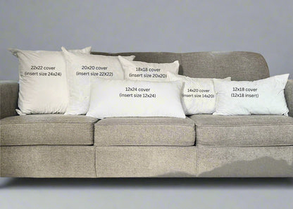 Gray sofa with white pillows of different sizes labeled on a wooden floor.
