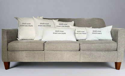 Gray sofa with white pillows displaying text about cover sizes.
