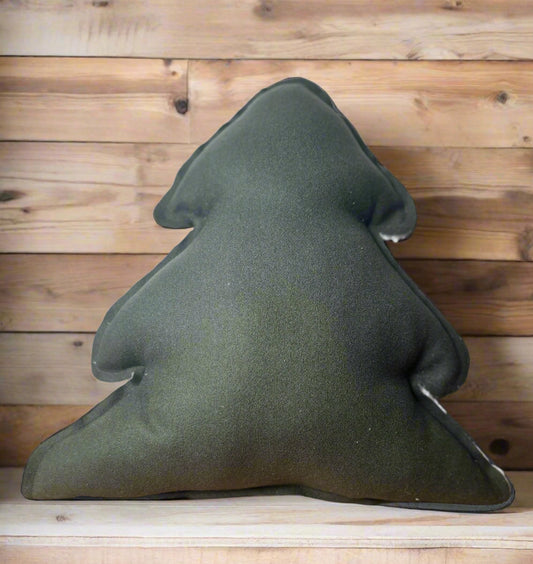 Green triangular pillow on a wooden surface with a white wall background