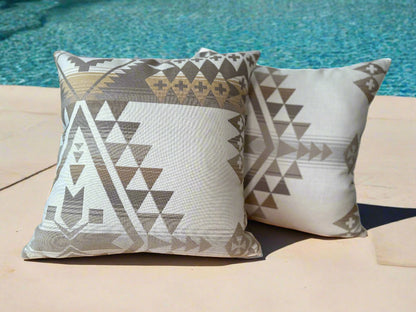 Two patterned pillows on a wooden surface with a blurred background