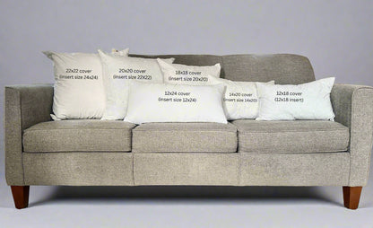 Gray sofa with white pillows displaying text about cover sizes.