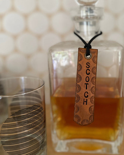Glass decanter of Scotch with a glass on a textured surface