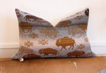 Decorative pillow with buffalo and bison pattern on a wooden surface