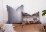 Gray and cream herringbone wool pillow cover styled with a western bison print lumbar pillow on a rustic bench