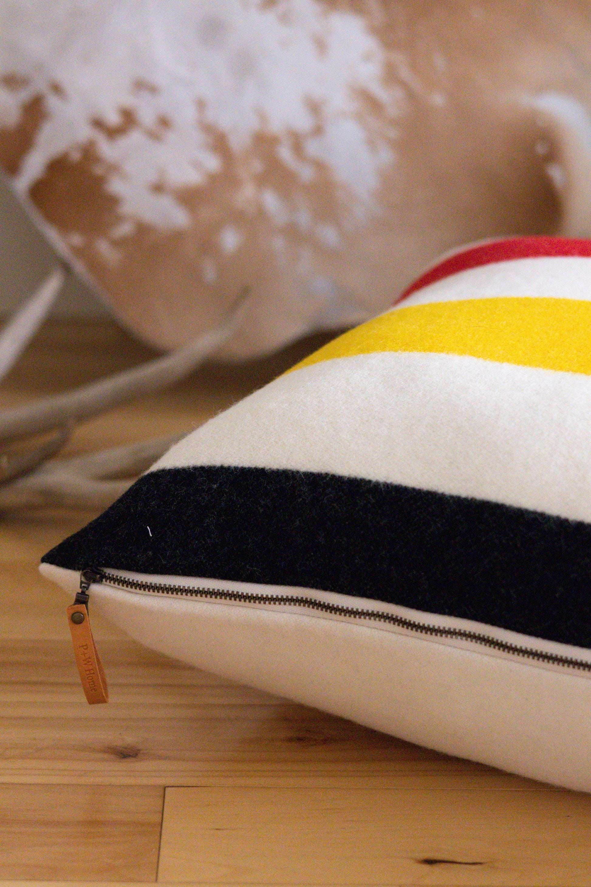 Close-up of a striped pillow with a cow in the background