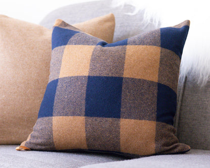 Plaid pillow on a sofa with a neutral background