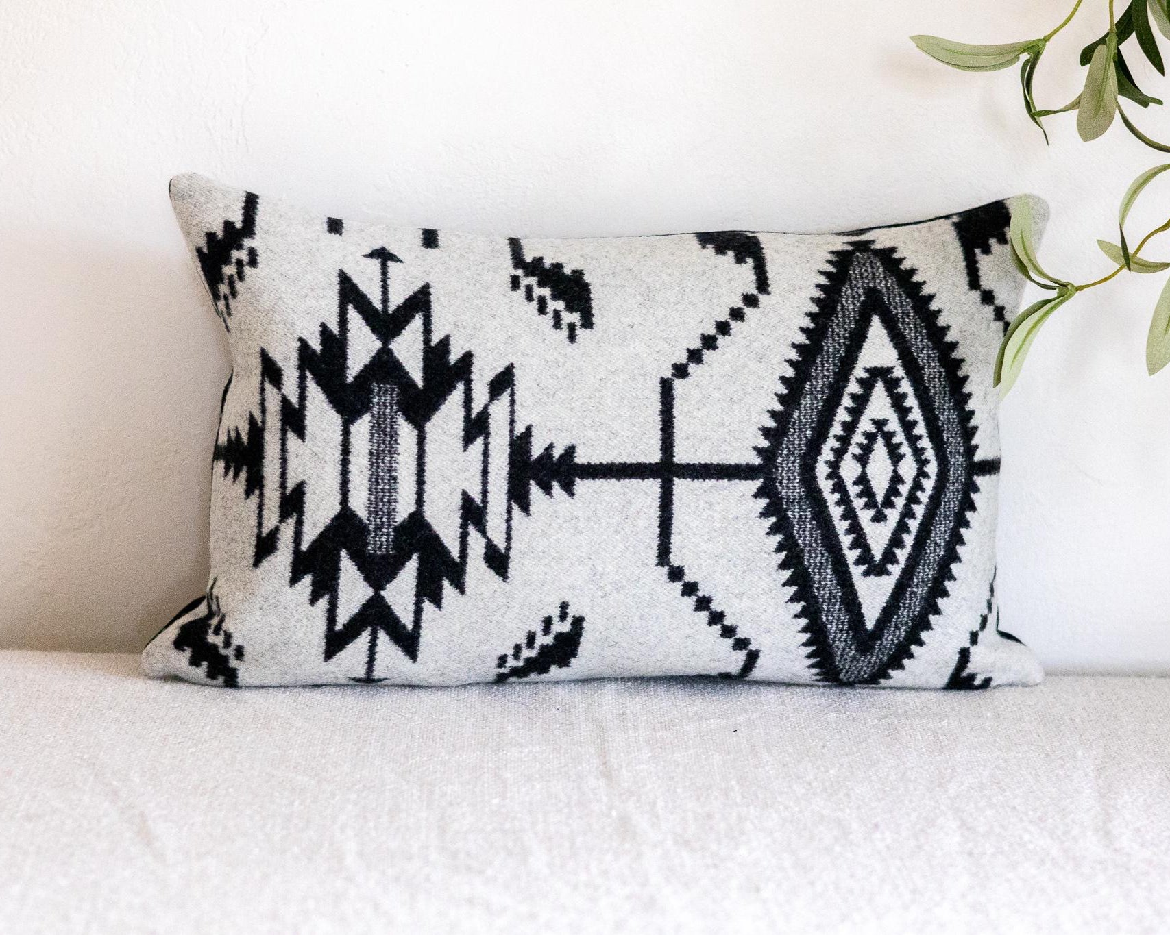 Decorative pillow with black geometric pattern on a white couch