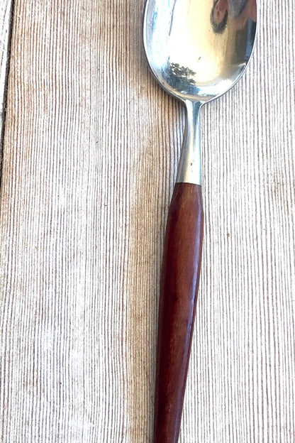 Spoon with a wooden handle on a wooden surface