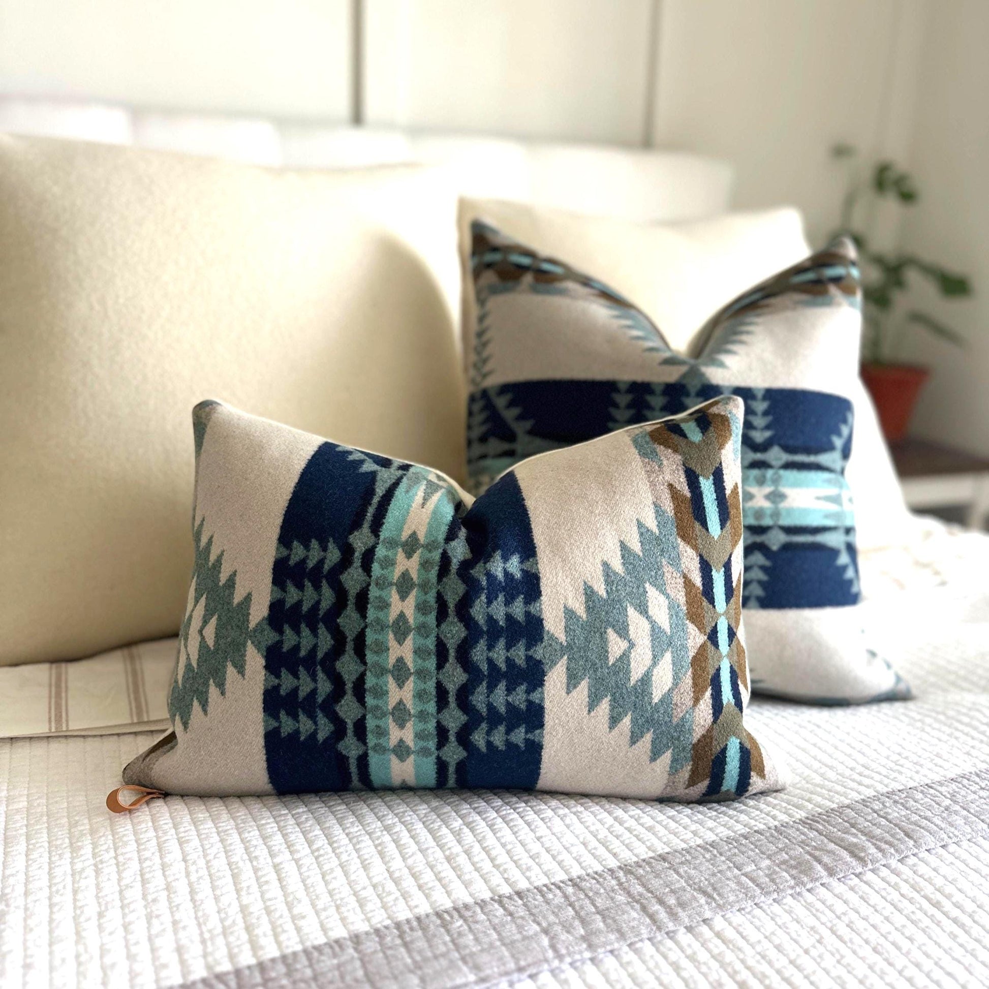 Decorative pillows with blue and beige patterns on a bed.